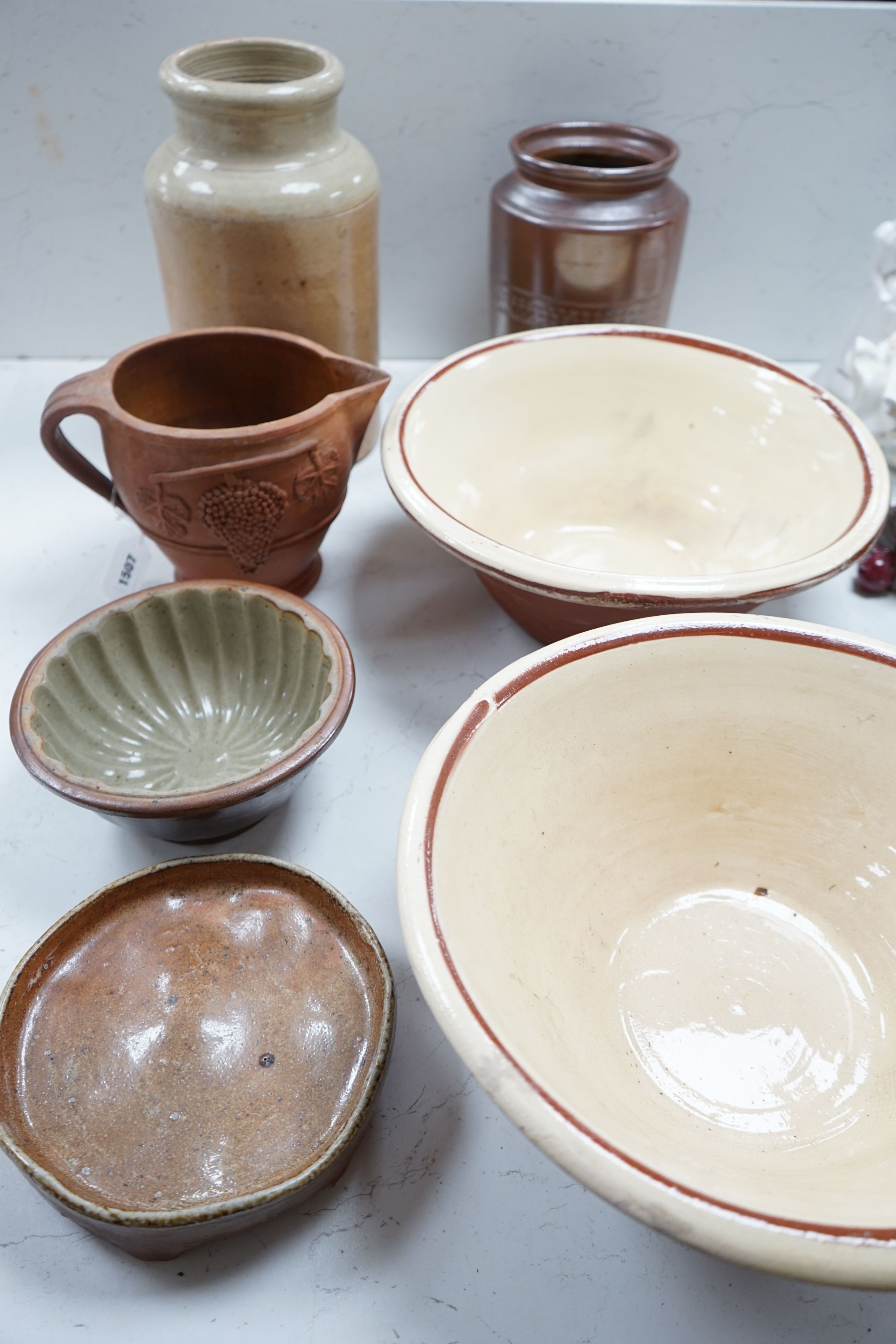 Two Victorian stoneware jars, tallest 33cm, together with two Victorian dairy bowls, a stoneware trivet, a jelly mould and a terracotta jug (7)